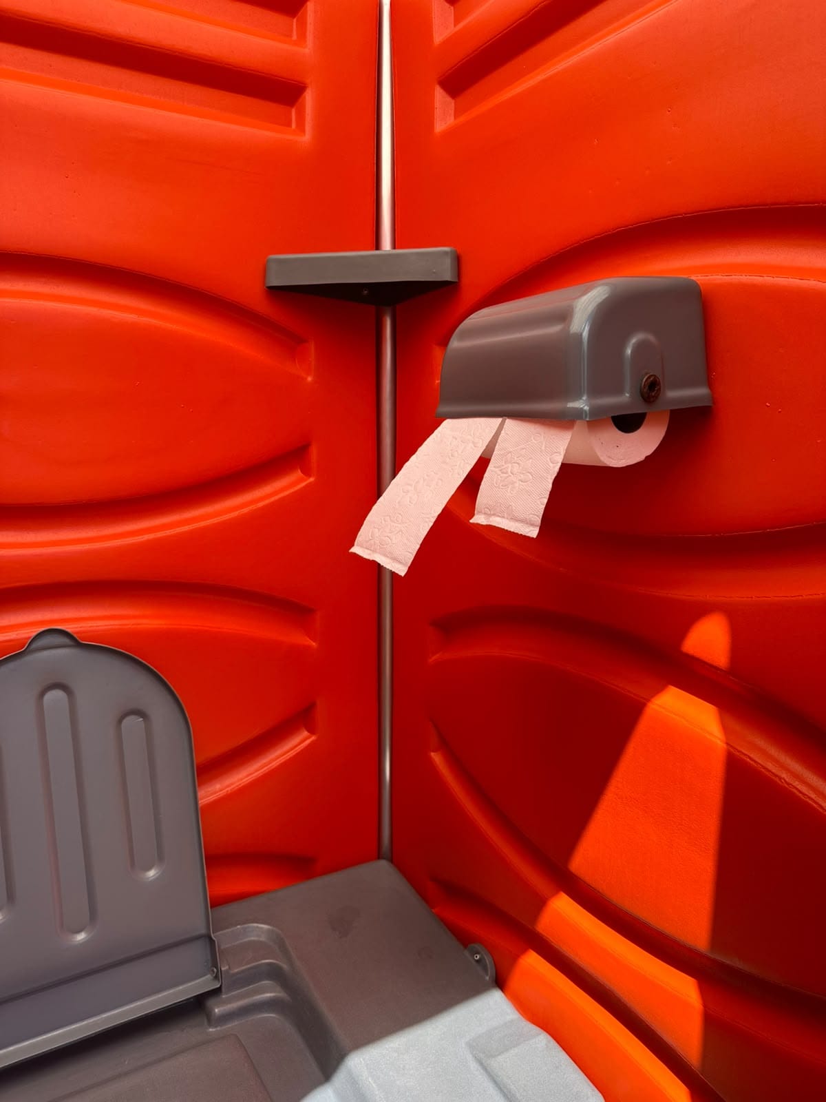 Suporte com rolos de papel higiênico na parede interna do banheiro STD