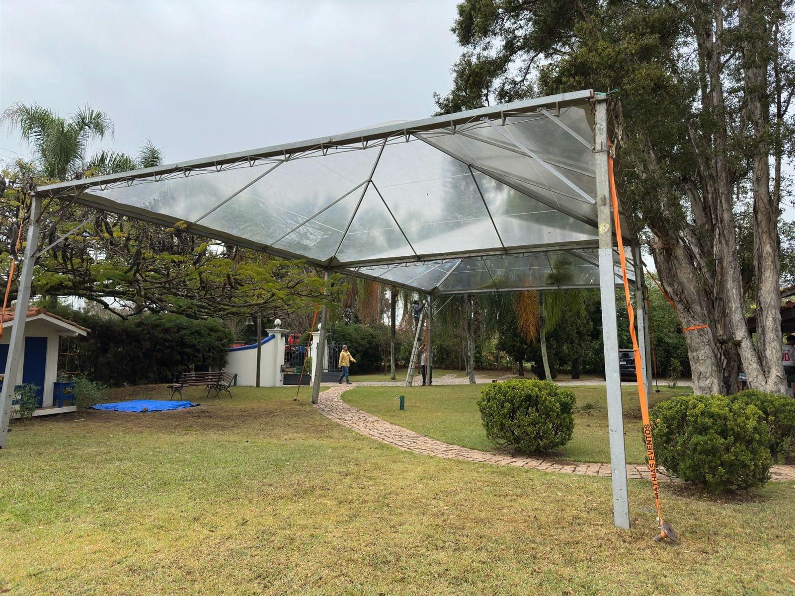 Tenda com cobertura transparente montada no jardim de um condomínio