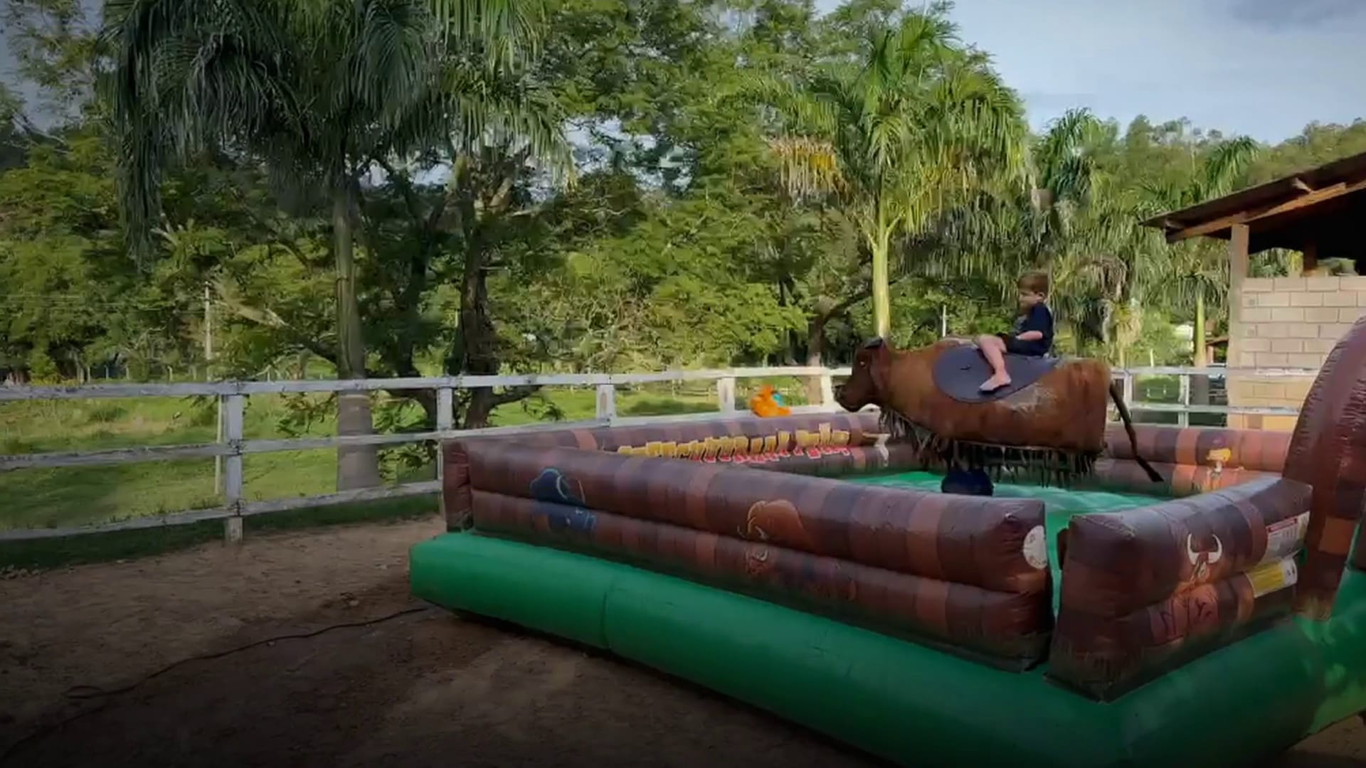 Criança montada no touro mecânico da Mathias Eventos, no centro da arena inflável